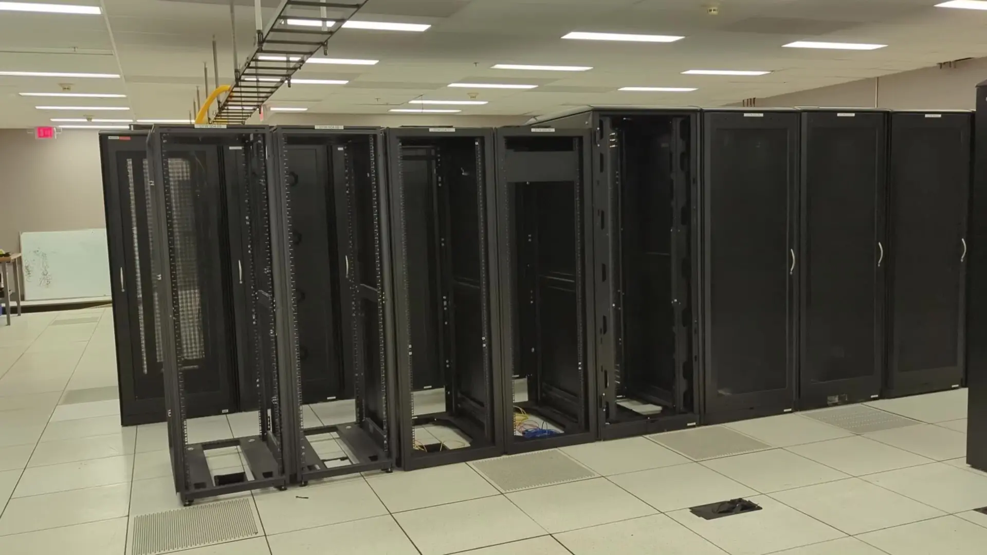 Rows of server cabinets on a raised floor in a data center